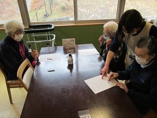 2月の茶話会で職員と一緒に問題を解いている入居者様