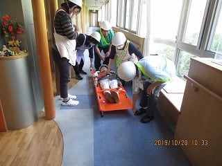 介助の避難活動の訓練をしている職員たち