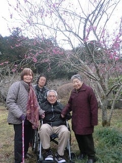 洞慶院の梅の花と利用者様たちの記念写真