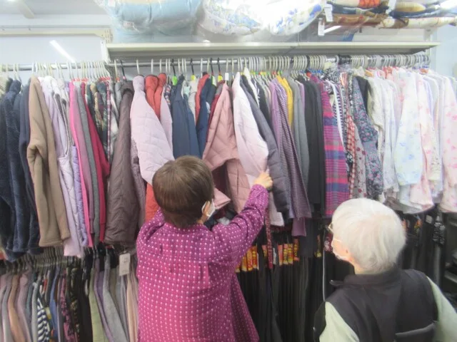 カリタスみわの入居者様がトラヤの移動販売車の中で売られている服を見ている写真