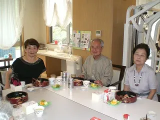 敬老会の食事のお寿司を食べている入居者様たち